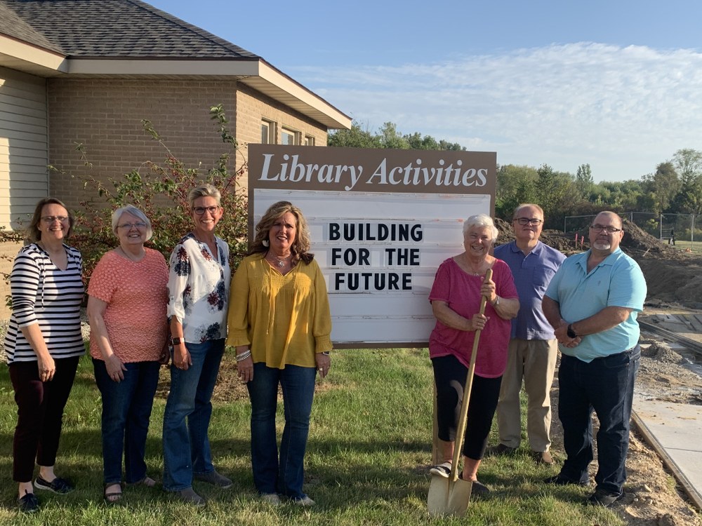 board members board members with shovel in front of library